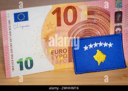 Die Flagge des Kosovo vor dem Hintergrund der gemeinsamen Währung der Europäischen Union, das Konzept des Beitritts des Kosovo zur Eurozone, Nahaufnahme Stockfoto