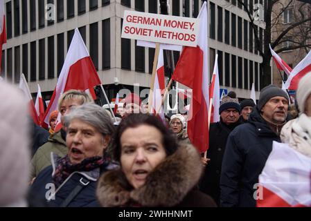 Protest Gegen Die Regierung In Warschau. Demonstranten rufen Parolen, schwenken die polnischen Nationalflaggen und halten ein Schild mit deutschem Geld und sowjetischen Methoden während eines regierungsfeindlichen Protests am 10. Februar 2024 in Warschau, Polen. Mehrere Hunderte Anhänger der Partei für Recht und Gerechtigkeit der PiS versammelten sich vor dem Verfassungsgericht in Warschau zu einem anti-staatlichen Protest gegen die Regierungskoalition unter der Führung des pro-europäischen Donald Tusk. Warschau Polen Copyright: XAleksanderxKalkax Stockfoto