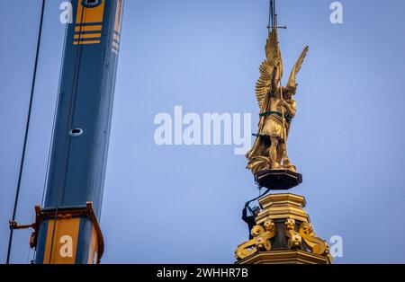 Schwerin, Deutschland. Februar 2024. Der Erzengel Michael wird zur Restaurierung mit einem Mobilkran aus der Goldkuppel des Schlosses Schwerin entfernt und für den Transport in eine Werkstatt auf einen LKW geladen. Die Figur stammt aus dem Jahr 1857 und wird offiziell „Erzengel Michael tötet den Drachen“ genannt. Der Erzengel wird nun in einer Berliner Werkstatt gereinigt, restauriert und neu vergoldet, bevor er im Sommer wieder in die Burg zurückkehrt. Der 'Erzengel Michael tötet den Drachen' wurde zuletzt vor 30 Jahren restauriert. Quelle: Jens Büttner/dpa/Alamy Live News Stockfoto