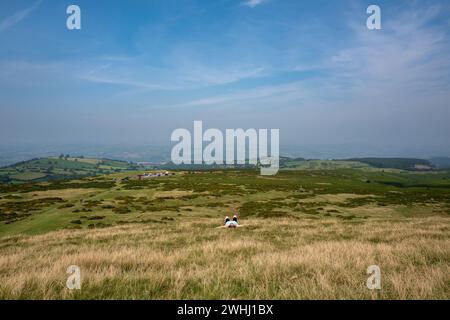 Eine Frau, die in der Sonne auf halbem Weg auf dem Bluff in Hay-on-Wye ruht Stockfoto