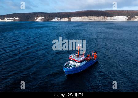 PRODUKTION - 01. Februar 2024, Mecklenburg-Vorpommern, Sassnitz: Das Fischereiforschungsschiff Clupea ist in der Ostsee vor der Insel Rügen unterwegs (Foto mit Drohne). An verschiedenen Stellen wird eine Hydrographie-Sonde verwendet, um den Sauerstoffgehalt, die Wassertemperatur und den Salzgehalt in allen Wassertiefen zu messen. Wissenschaftler des Thünen-Instituts untersuchen derzeit die Auswirkungen der Bauarbeiten für die Erdgaspipeline von Mukran nach Lubmin. Große Heringsschwärme versammeln sich im Winter in der Sassnitzer Gully und ziehen von hier aus zum Laichen im Greifswalder Bodden. Foto: Je Stockfoto