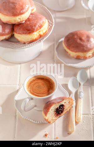 Traditionell und hausgemachte Donuts in Öl frittieren. Donuts mit Pflaumenmarmelade und Glasur. Stockfoto