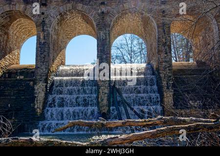 Nahaufnahme teilweiser Blick auf die Rückseite der Bogenbrücke im Cumberland Mountain State Park mit einem kräftigen Wasser, das in den Bach darunter fließt Stockfoto