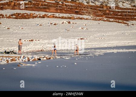 Fort Collins, CO, USA - 4. Februar 2024: Gruppe junger Menschen, die in einem Eisloch im Frozen Horsetooth Reservoir in Colorado f Stockfoto