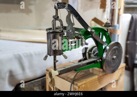 Industrielle Nähmaschine für Lederarbeiten mit Schwungrad und rotierendem Nähfuß in der Handwerkstatt, für Taschen verwendet, Stockfoto