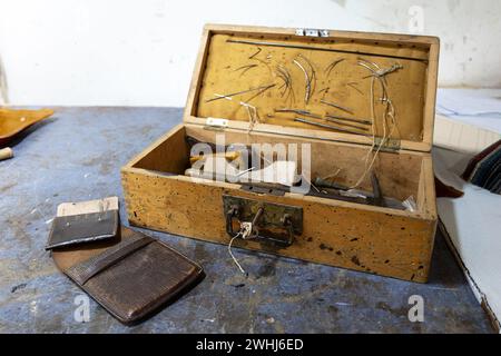 Alte Holzwerkzeugkiste von einem Polsterer mit Nadeln und verschiedenen Handwerkzeugen, die für die Arbeit unterwegs verwendet werden, traditionelle Handwerkskunst, Stockfoto