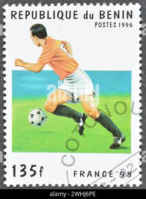 Von Benin gedruckte Briefmarke für stornierte Porto, die den Fußballspieler zeigt, der die FIFA-Weltmeisterschaft 98 in Frankreich um 1996 bewirbt. Stockfoto