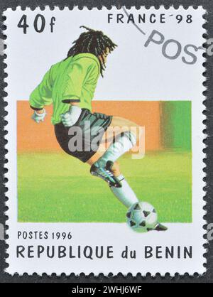 Von Benin gedruckte Briefmarke für stornierte Porto, die den Fußballspieler zeigt, der die FIFA-Weltmeisterschaft 98 in Frankreich um 1996 bewirbt. Stockfoto