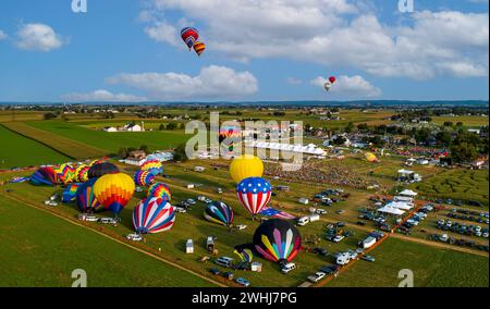 Aus der Vogelperspektive sehen Sie viele Heißluftballons, die während eines Ballonfestivals starten und davongleiten Stockfoto