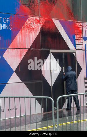 London, Großbritannien. Februar 2024. Als Demonstranten, die ein Ende des Völkermords in Israel forderten, vor dem Büro von BAE Systems im Bluefin Building in der Southwark Street ankamen, fanden sie Arbeiter vor, die mit der Reinigung der roten Farbe beschäftigt waren, die zuvor auf die Fassade gesprüht worden war. BAE liefert Israel Schlüsselkomponenten von Kampfflugzeugen, Munition, gepanzerten Fahrzeugen und Raketenstartkits, bei denen inzwischen 28.000 Frauen und Kinder im Gazastreifen getötet wurden. Demonstranten fordern Großbritannien auf, die Waffenlieferungen an Israel einzustellen. Peter Marshall/Alamy Live News Stockfoto