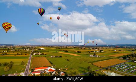 Aus der Vogelperspektive sehen Sie viele Heißluftballons, die während eines Ballonfestivals starten und davongleiten Stockfoto