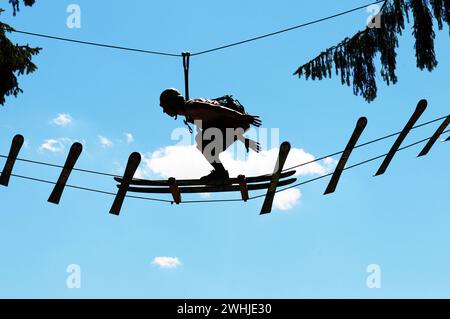 Tirol: Ein Mann balanciert im Zillertaler Hochseilgarten wie ein Skispringer auf den Brettern . Ein Mann balanciert auf den Skiern im Adventure-Park i Stockfoto