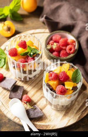 Sommer gesunde Ernährung Frühstück, Snackkonzept. Triffle Schokoladenkekse mit Joghurt und frischen Beeren und Früchten. Zwei Teile Stockfoto