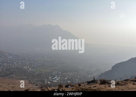 Srinagar, Indien. Februar 2024. Ein Mann spaziert an einem kalten Wintertag am Rande von Srinagar, der Sommerhauptstadt von Jammu und Kaschmir, entlang des Hügels von Zabarwan. (Foto: Saqib Majeed/SOPA Images/SIPA USA) Credit: SIPA USA/Alamy Live News Stockfoto