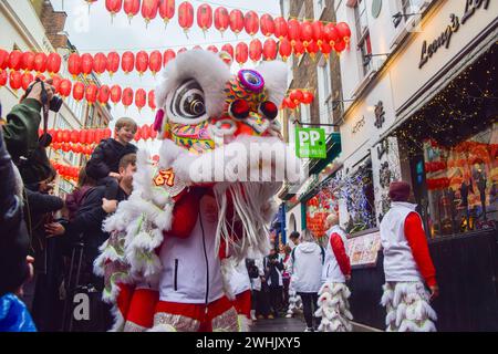 Löwentänzer treten auf, um zum chinesischen Neujahr in Londons Chinatown Glück in Restaurants und Geschäften zu bringen. Stockfoto