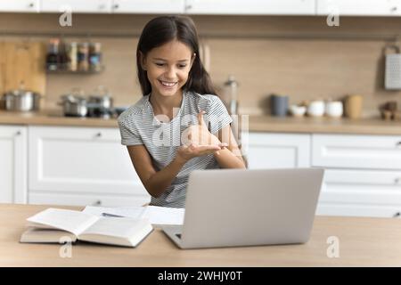 Positives Mädchen im Jugendalter mit Hörbehinderung mit Laptop Stockfoto