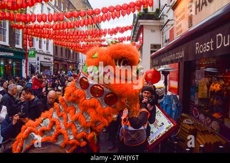 Löwentänzer treten auf, um zum chinesischen Neujahr in Londons Chinatown Glück in Restaurants und Geschäften zu bringen. Stockfoto