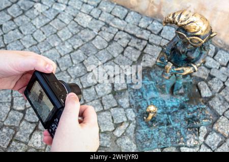 Breslauer Zwerge Troszka und Adoratorek werden von Touristen auf dem Hauptplatz fotografiert, also Zwerge auf dem Kamerabildschirm Stockfoto