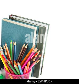 Set mit farbigen Bleistiften und Büchern auf weißem Hintergrund. Es ist freier Platz für Text vorhanden. Stockfoto