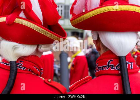 Wetzlar, Deutschland. Februar 2024. Während der kleinen Karnevalsparade der Wetzlarer Karnevalsgesellschaft am Karnevalssamstag stürmen die Karnevalskünstler symbolisch das Rathaus am Fischmarkt in der historischen Altstadt von Wetzlar, entreißen dem Richter (Leitung der Stadtverwaltung) den Schlüssel zum Rathaus und übernehmen Sie die Stadtverwaltung. Hier beobachten Mitglieder der Fürstengarde den Tatort. Credit: Lademannmedia/Alamy Live News Stockfoto