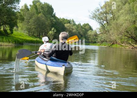 Familien-Kajakausflug für Seigneur und Senora. Ein älteres Ehepaar rudert ein Boot auf dem Fluss, eine Wasserwanderung, ein Sommerabenteuer Stockfoto