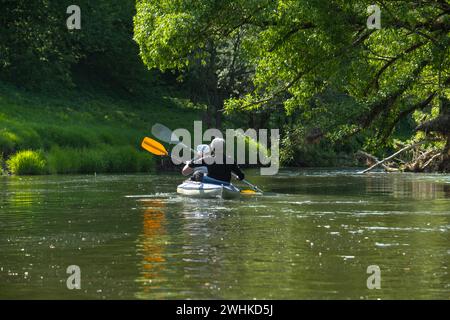 Familien-Kajakausflug für Seigneur und Senora. Ein älteres Ehepaar rudert ein Boot auf dem Fluss, eine Wasserwanderung, ein Sommerabenteuer Stockfoto