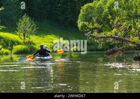 Familien-Kajakausflug für Seigneur und Senora. Ein älteres Ehepaar rudert ein Boot auf dem Fluss, eine Wasserwanderung, ein Sommerabenteuer Stockfoto