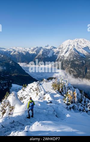 Tourist auf einem Wanderweg, schneebedeckter Gipfel des Jenners mit Aussichtsplattform im Herbst, Blick auf das Wolkenmeer und Watzmann, Berchtesgaden Stockfoto