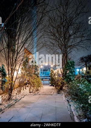 Dicke schneebedeckte hölzerne Schaukelbank im Kaffeegarten Stockfoto