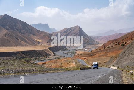 Lkw auf dem Pamir Highway, Bergstraße durch erodierte Berglandschaft, Kirgisistan Stockfoto