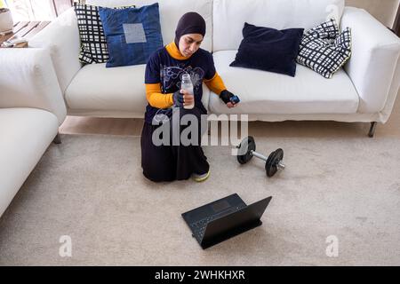 muslimische Frau, die zu Hause Übungen macht Stockfoto