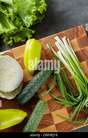 Frisches grünes Gemüse auf hölzernem Schneidebrett Stockfoto
