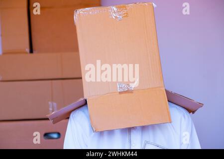 Ein arabischer Mann, der einen Karton auf den Kopf legt Stockfoto