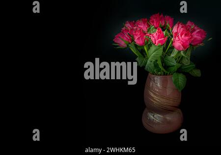 Hübsche rot-rosa Rosen dekorativ in einer Glasvase auf dunklem Hintergrund zum Valentinstag. Symbol der Liebe, Raum für Text, selektiver Fokus. Stockfoto