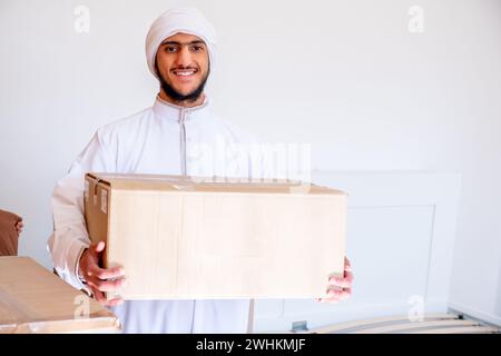 Ein arabischer Mann hält eine Kiste mit einem Zeichentrickfilm Stockfoto
