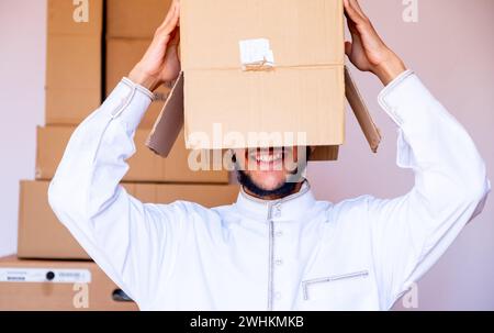 Ein arabischer Mann, der einen Karton auf den Kopf legt Stockfoto