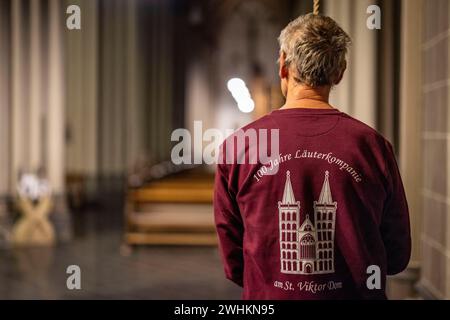 Xanten, Deutschland. Februar 2024. Ein Mitglied der Ringing Company steht in St. Viktor-Kathedrale. Die „Klingelgesellschaft“ im Dom von Xanten läutet am Sonntag von Hand 13 Männer, die meisten Rentner, läuten die drei großen Glocken des Doms von Hand an 40 Meter langen Seilen. Sie folgen einer festen Choreographie - manchmal hängen sie drei an ein Seil. Quelle: Christoph Reichwein/dpa/Alamy Live News Stockfoto