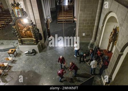 Xanten, Deutschland. Februar 2024. Die Mitglieder der Ringgesellschaft ziehen am Samstagabend drei Seile an, um die drei großen Glocken in der Kathedrale zu läuten. Die „Klingelgesellschaft“ im Dom von Xanten läutet am Sonntag von Hand 13 Männer, die meisten Rentner, läuten die drei großen Glocken des Doms von Hand an 40 Meter langen Seilen. Sie folgen einer festen Choreographie - manchmal hängen sie drei an ein Seil. Quelle: Christoph Reichwein/dpa/Alamy Live News Stockfoto