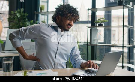 Müde krank arabischer hispanischer Geschäftsmann kranker Kerl leiden Rückenschmerzen Schmerzen im Rücken nach Laptop Computer Arbeit im Büro ungesunder Mann Geschäftsgeber Stockfoto