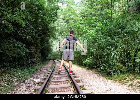 Junge männliche Touristen spazieren mit der Eisenbahn im Dschungel thailands Stockfoto