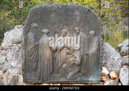 Die Darstellung Jesu – Viertes freudiges Geheimnis des Rosenkranzes. Eine Reliefskulptur auf dem Berg Podbrdo (der Hügel der Erscheinungen) in Medjugorje. Stockfoto