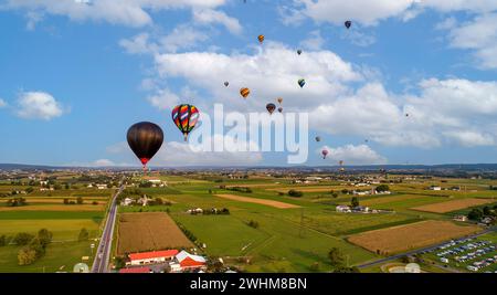 Aus der Vogelperspektive sehen Sie viele Heißluftballons, die während eines Ballonfestivals starten und davongleiten Stockfoto