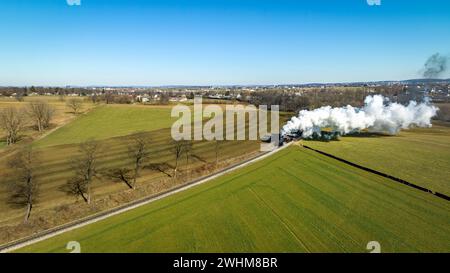 Luftlinie einer Dampferfracht, Passagierkombo-Zug nähert sich und bläst viel Rauch Stockfoto