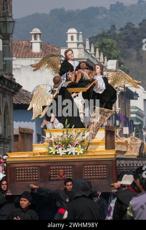 Antigua, Guatemala. Karfreitagsprozession. señor Sepultado, Christus nach der Kreuzigung, wird von Cucuruchos in Schwarz auf einem Ananda (Wagen) getragen. Stockfoto