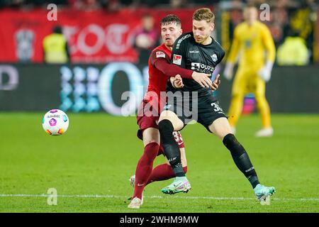 Kaiserslautern, Deutschland. Februar 2024. Fußball: Bundesliga 2, 1. FC Kaiserslautern - SC Paderborn 07, 21. Spieltag, Fritz-Walter-Stadion: Kaiserslautern Jan Elvedi (l) und Paderborns Felix Platte kämpfen um den Ball. Hinweis: Uwe Anspach/dpa – WICHTIGER HINWEIS: gemäß den Vorschriften der DFL Deutscher Fußball-Liga und des DFB Deutscher Fußball-Bundes ist es verboten, im Stadion und/oder des Spiels aufgenommene Fotografien in Form von sequenziellen Bildern und/oder videoähnlichen Fotoserien zu verwenden oder zu nutzen./dpa/Alamy Live News Stockfoto