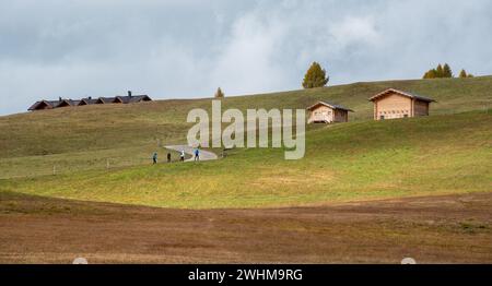 Windige Straße Chalet Holzhäuser. Menschen, die im Freien wandern. Gesunder Lebensstil Stockfoto