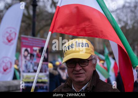 London, Großbritannien. Februar 2024. Ein Demonstrant hält während der Anglo-iranischen Gemeinde eine große iranische Flagge, um den Druck des iranischen Volkes auf eine neue Revolution zu unterstützen. Die anglo-iranische Gemeinschaft gedachte zusammen mit den Anhängern des Nationalen Widerstandsrates des Iran (NCRI) den 45. Jahrestag der demokratischen Revolution im Iran, die das theokratische Regime 1979 unterdrückte. Quelle: SOPA Images Limited/Alamy Live News Stockfoto