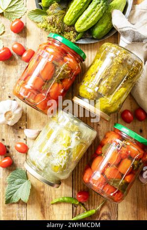 Gesunde hausgemachte fermentierte Lebensmittel. Gesalzene eingelegte Gurken und Tomaten, konserviert in Glasgefäßen. Hauswirtschaft, Herbsthar Stockfoto