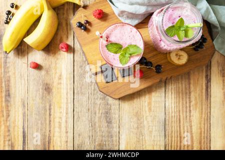 Himbeeren, Bananen und schwarze Johannisbeere. Set aus frischen verschiedenen leckeren Milchshakes oder Smoothies mit frischen Beeren. Ansicht von abo Stockfoto