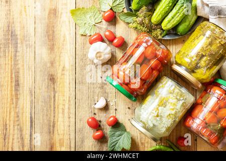 Gesunde hausgemachte fermentierte Lebensmittel. Gesalzene eingelegte Gurken und Tomaten, konserviert in Glasgefäßen. Hauswirtschaft, Herbsthar Stockfoto